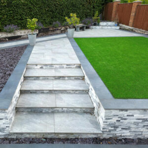 Elevated view of landscaped garden with contrasting light and dark grey porcelain tiles. No people.