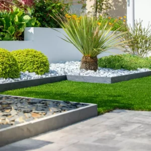 Aménagement de jardin paysagé, plante et fleur au pied d'une maison moderne.